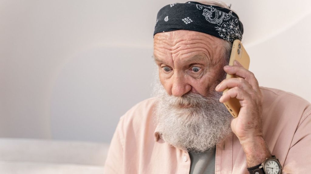 A man on the phone looking shocked