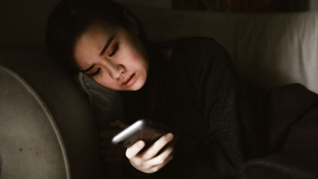 A woman using her phone at night