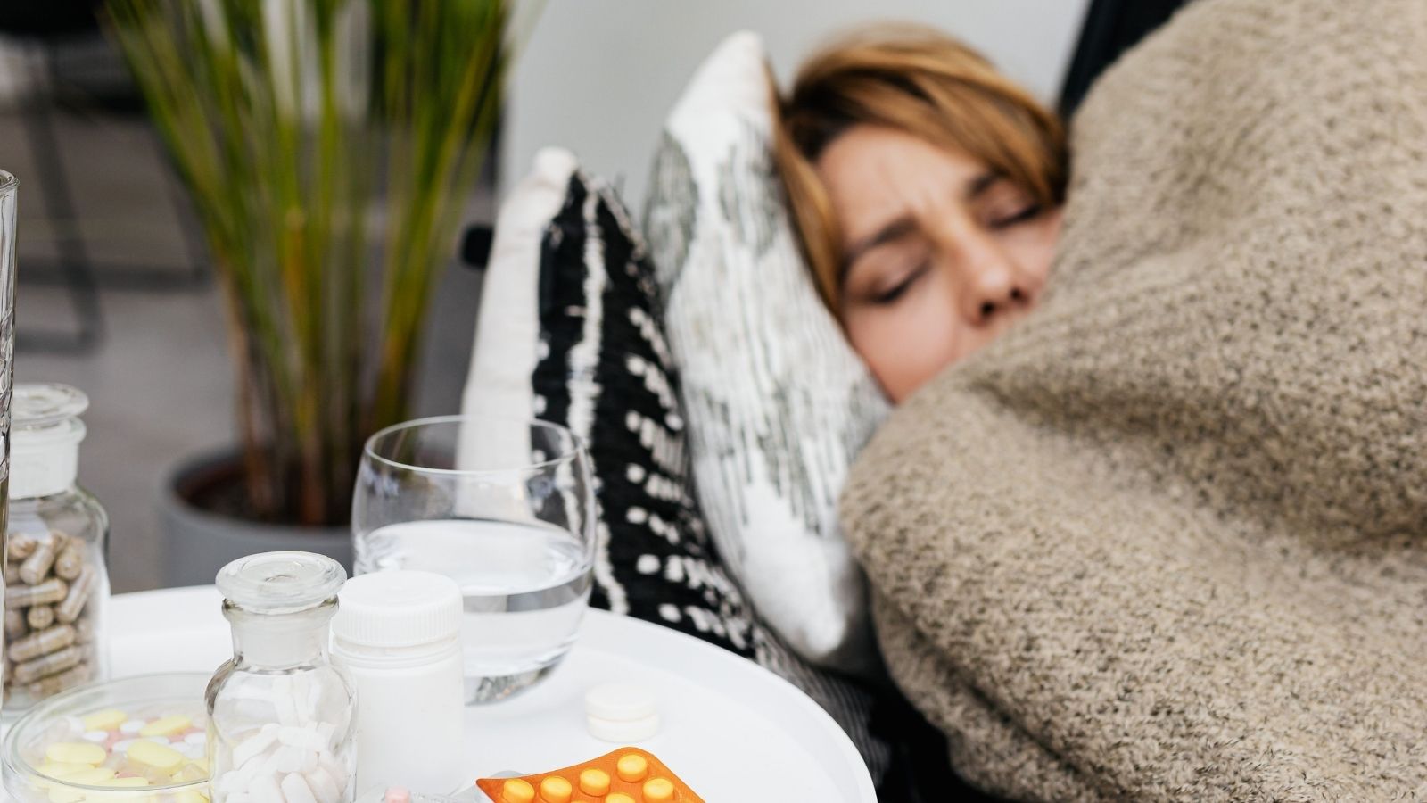 A sick person sleeping beside medicine