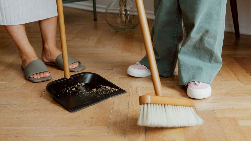 People using a dustpan and broom