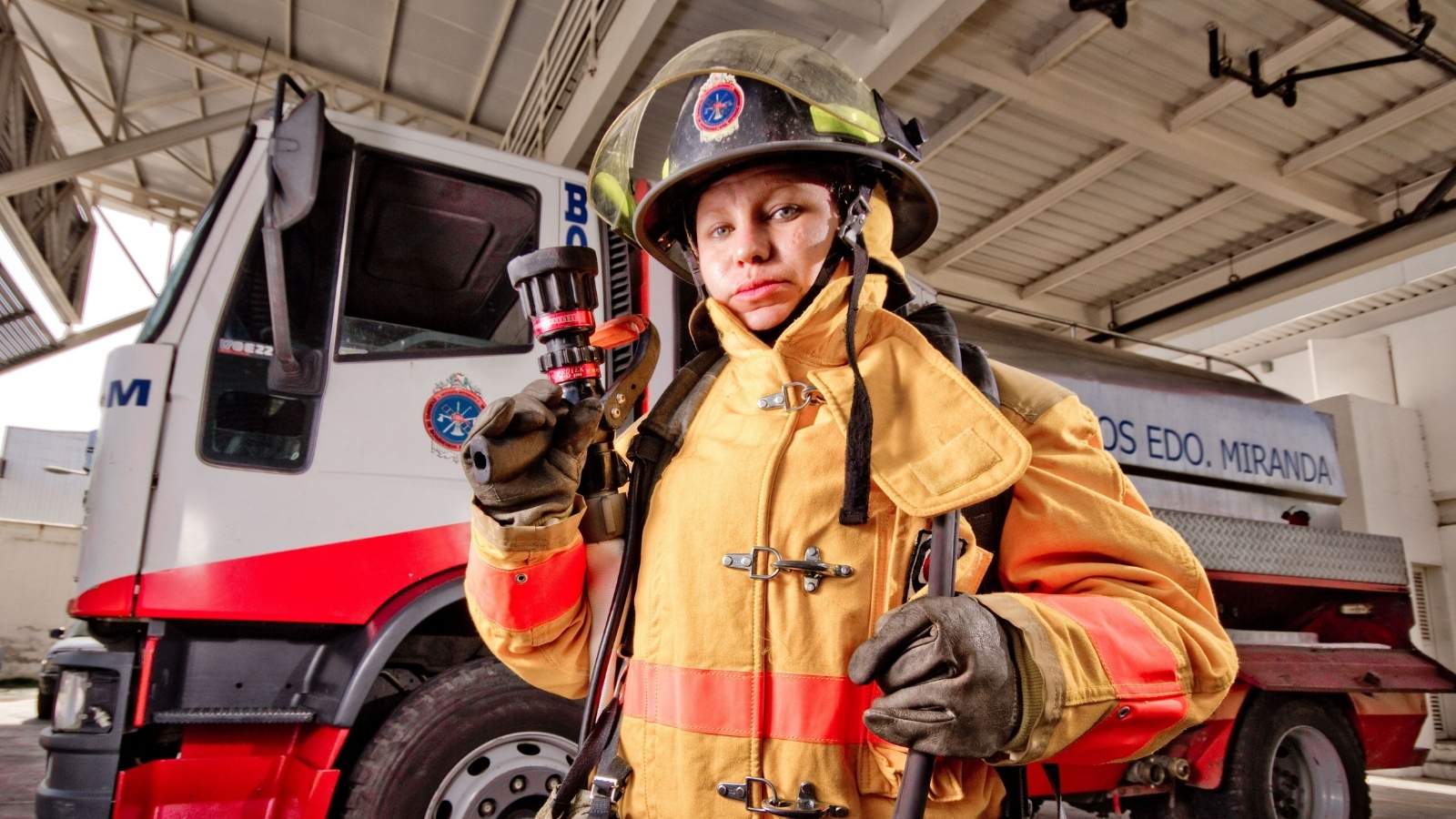 The Travel Photo Backlash: Firefighter Faces Online Outrage After Posting Picture on Job Assignment Female firefighter standing in front of truck