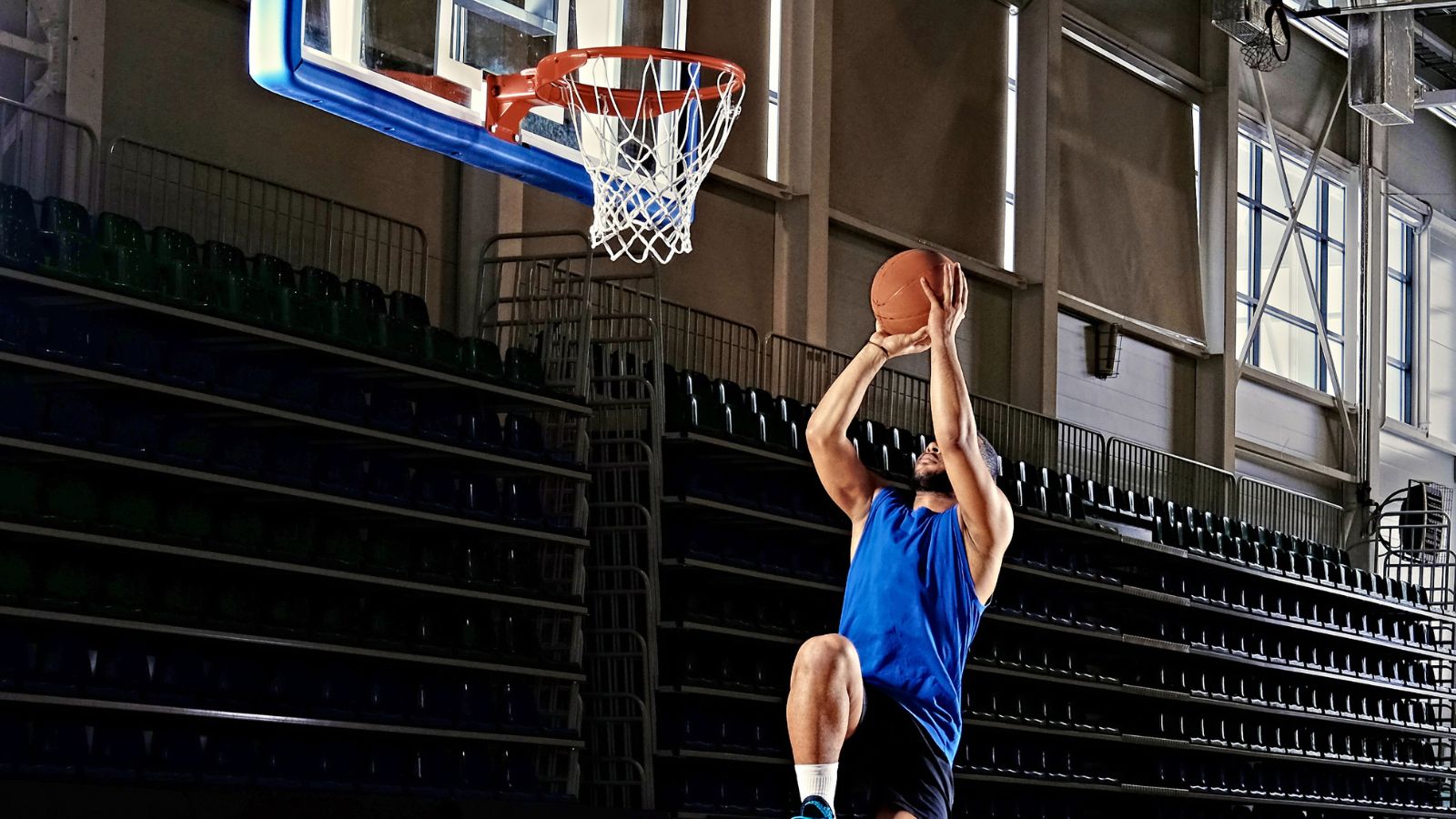 Man playing basketball and trying to shoot the ball in the ring