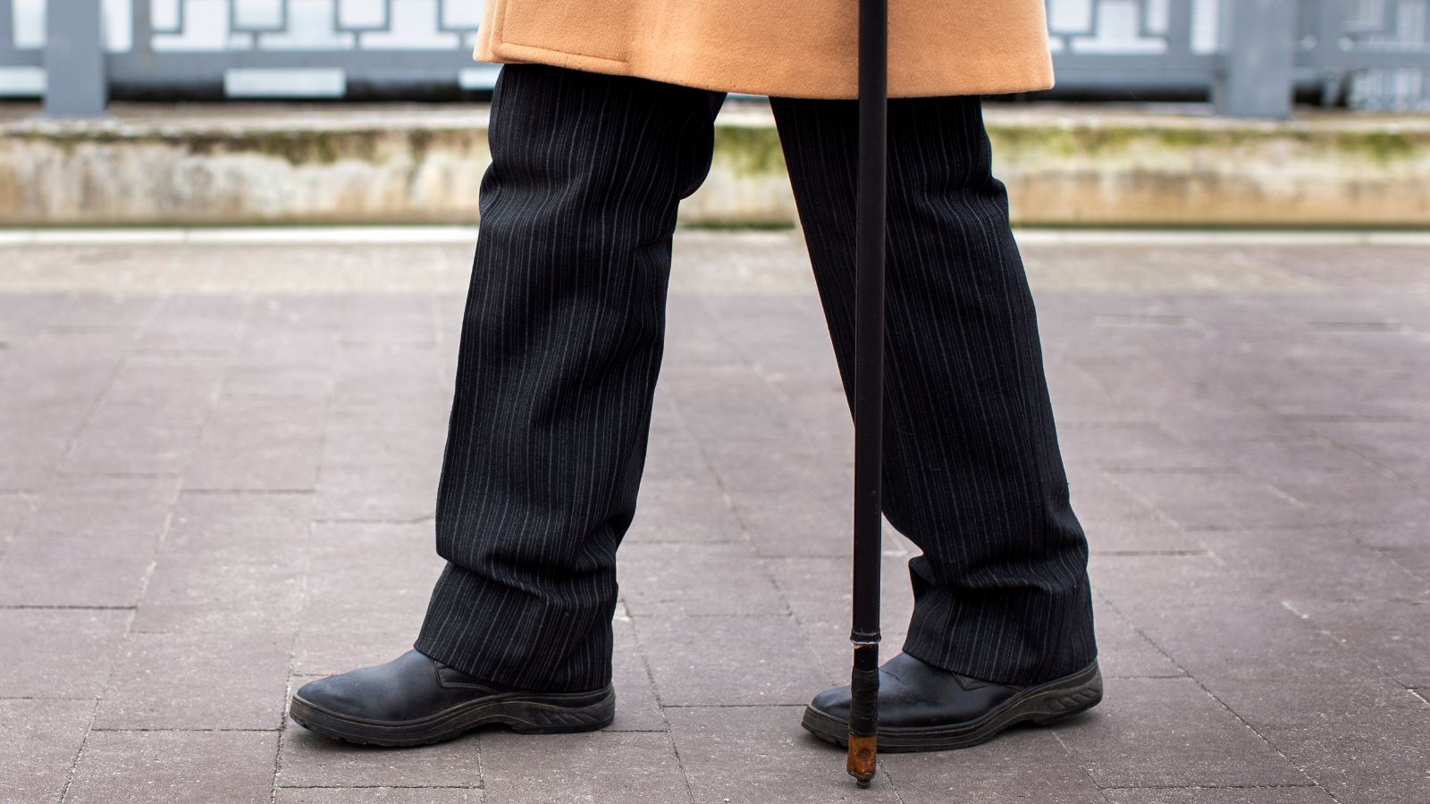 Man with a stick walking outdoors