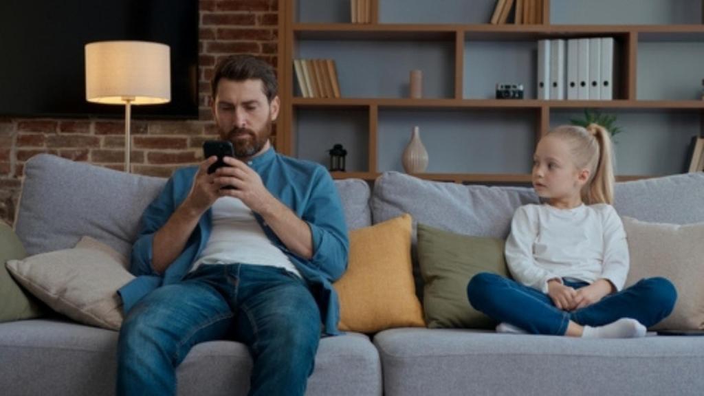 Father on phone neglecting daughter