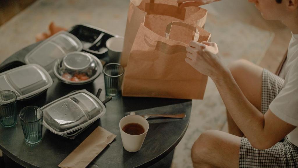 Man sitting at a table eating his takeout food