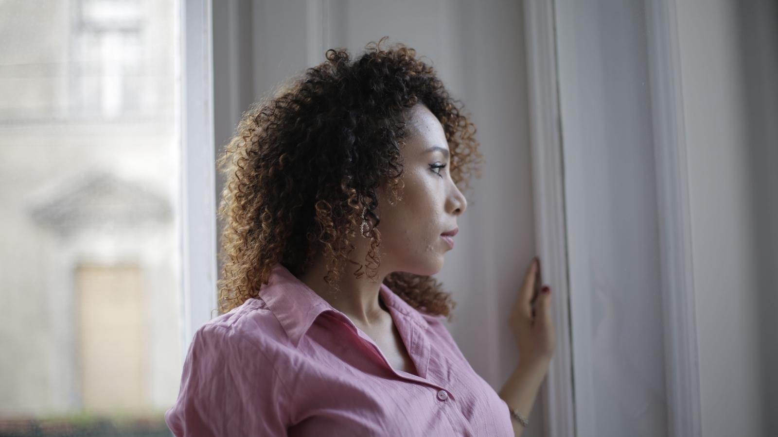 Woman staring out apartment window