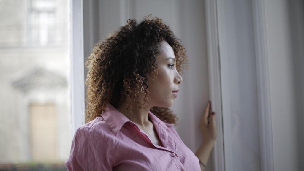 Woman staring out apartment window
