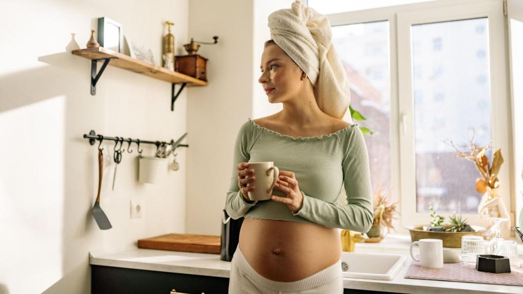 Pregnant woman drinking tea in the kitchen