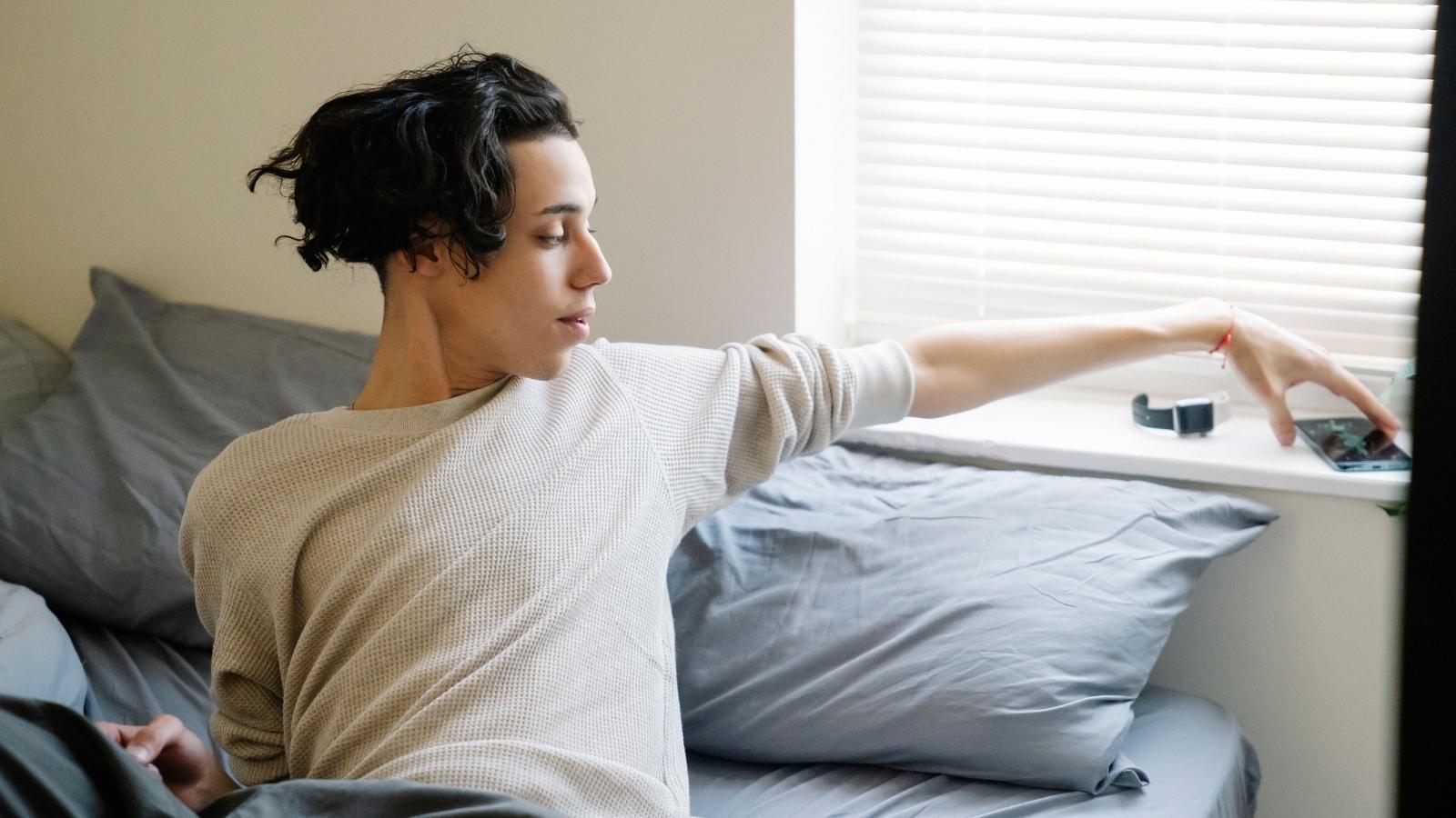 He Defended His Bachelors Thesis and Slept Through More Than 30 Calls — His Family Was Convinced He Was Partying College student waking up and reaching for his phone
