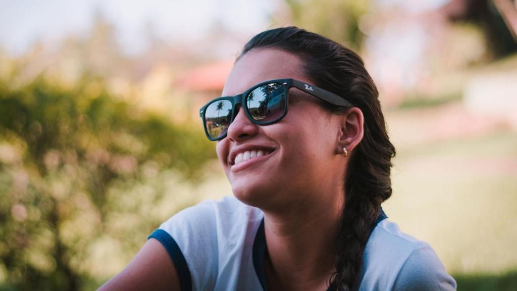 Woman smiling outside in her Rayban glasses