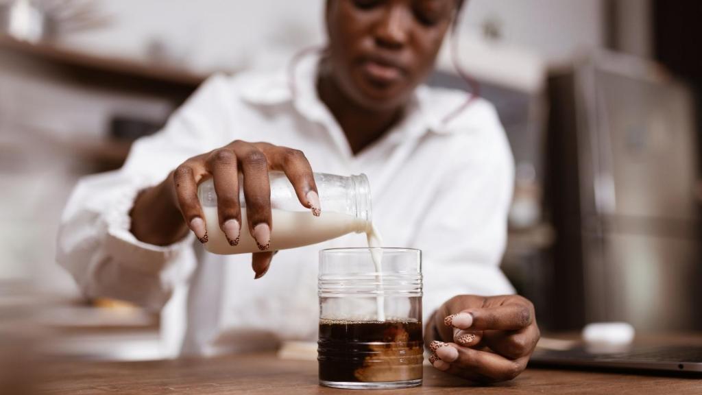 Woman finally pouring the creamer in her coffee