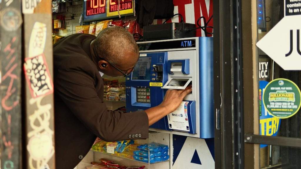 Bodega owner fixing the ATM