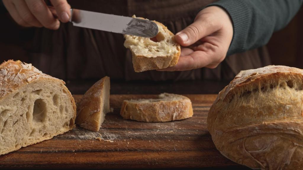 Woman putting butter on sourdough bread