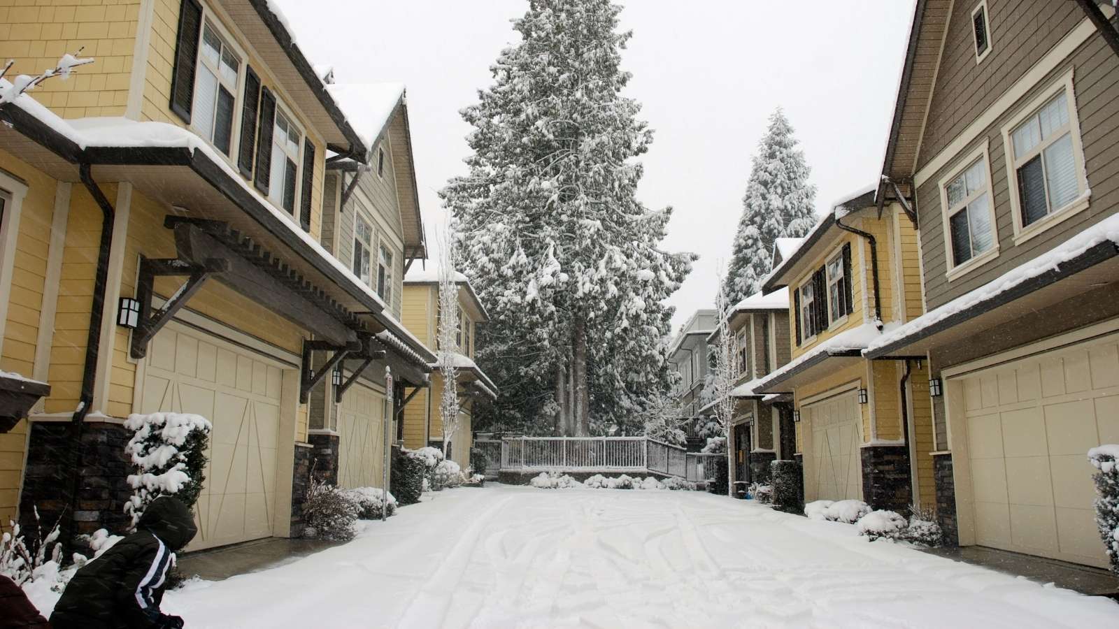Townhouses with connected driveways covered in snow