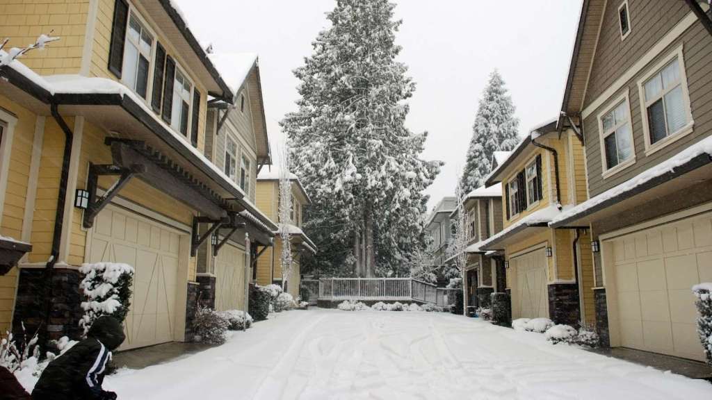 Townhouses with connected driveways covered in snow