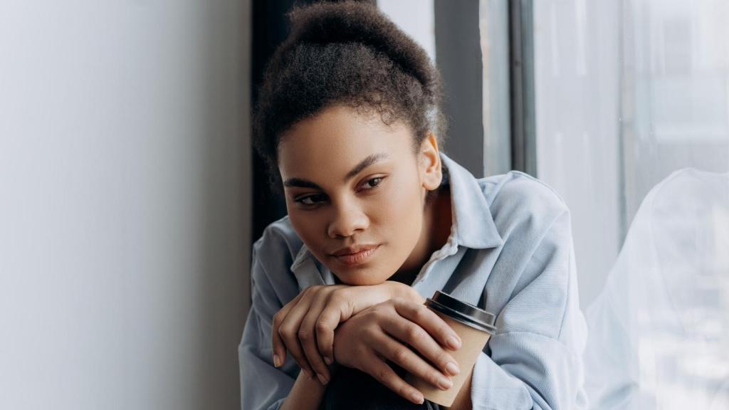 Woman drinking coffee and thinking about her friend