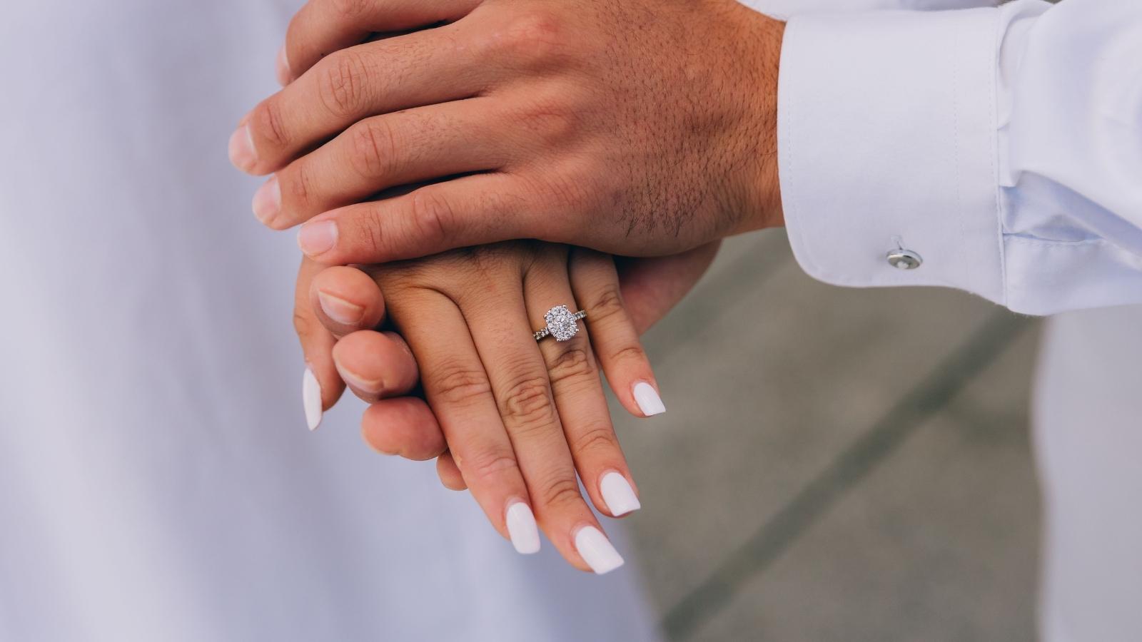 The Stolen Milestone: Why a Bride to Be Is Heartbroken After Her Mom Debuted an Identical Custom Ring. Man holding a woman's hand with an engagement ring