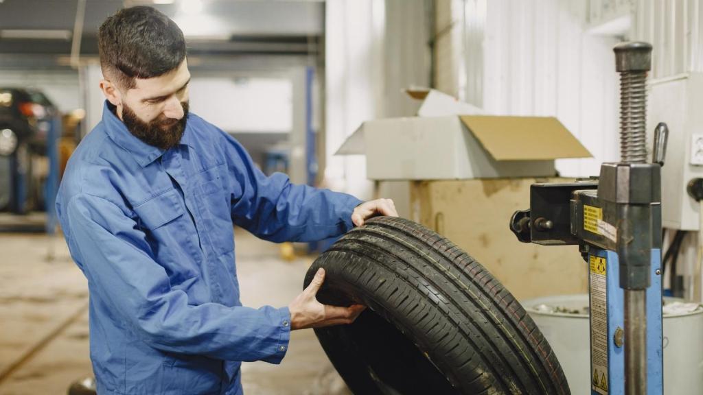 Tire shop employee grabbing a tire for customer