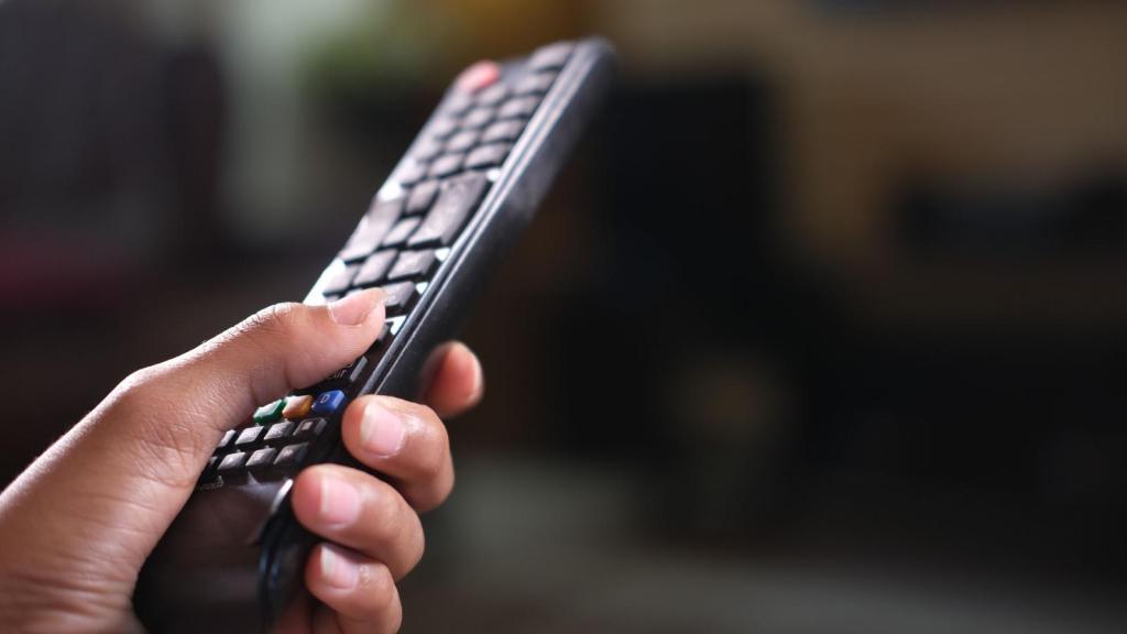 Man holding remote to set TV up