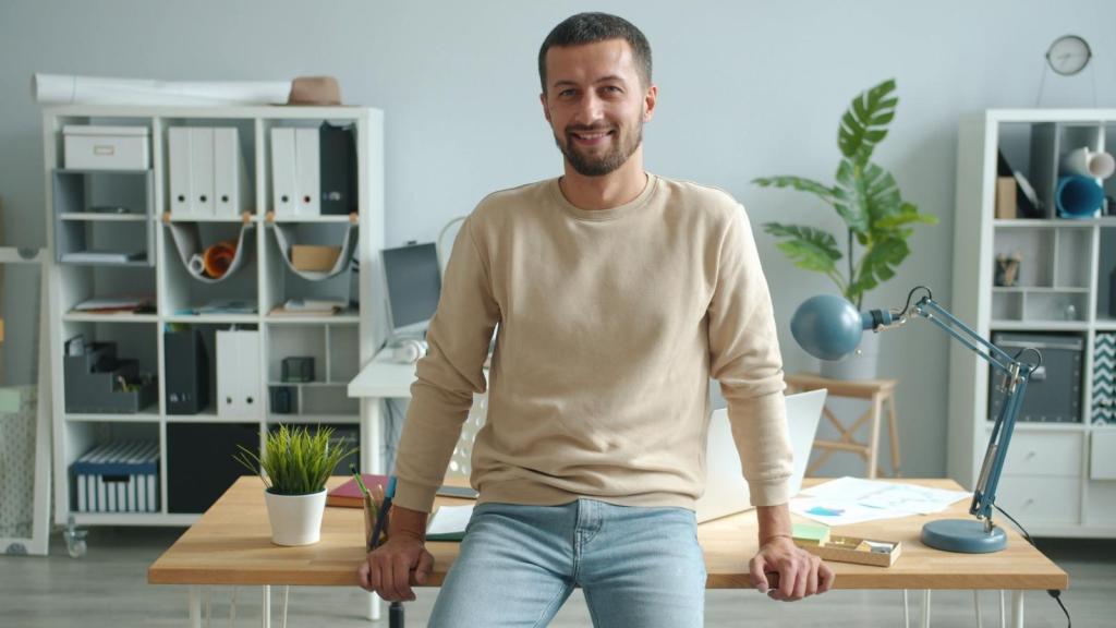 Man leaning up against his desk, happy the manager is gone