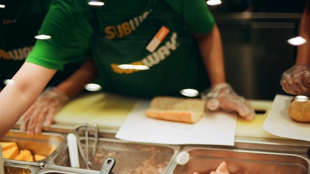 Subway employee making a sandwich for a customer