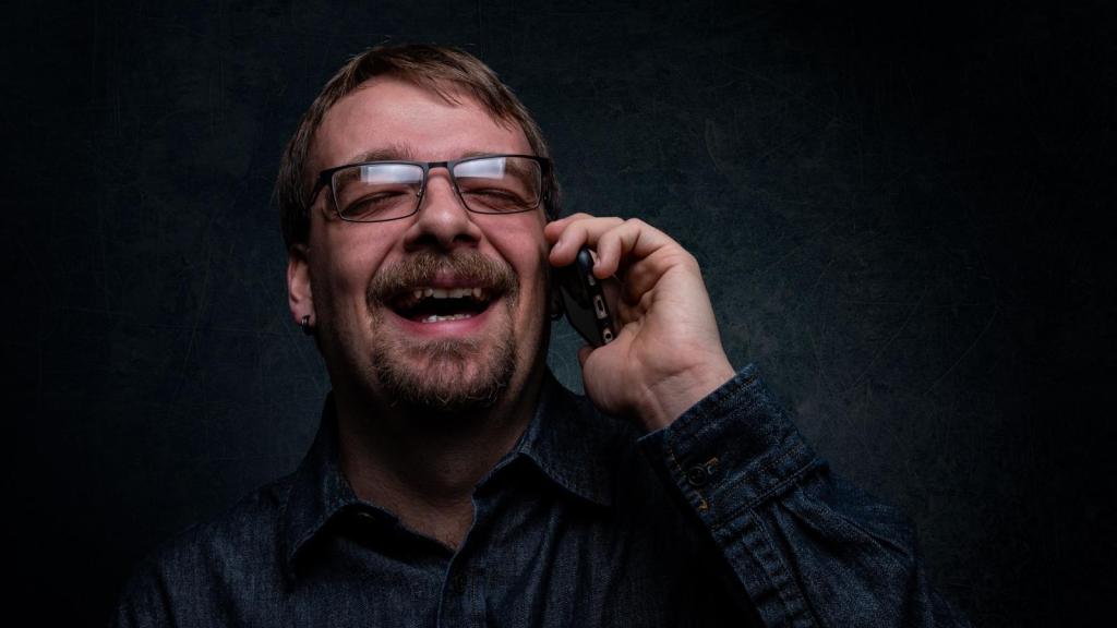 Man laughing as he exposes someone on the phone