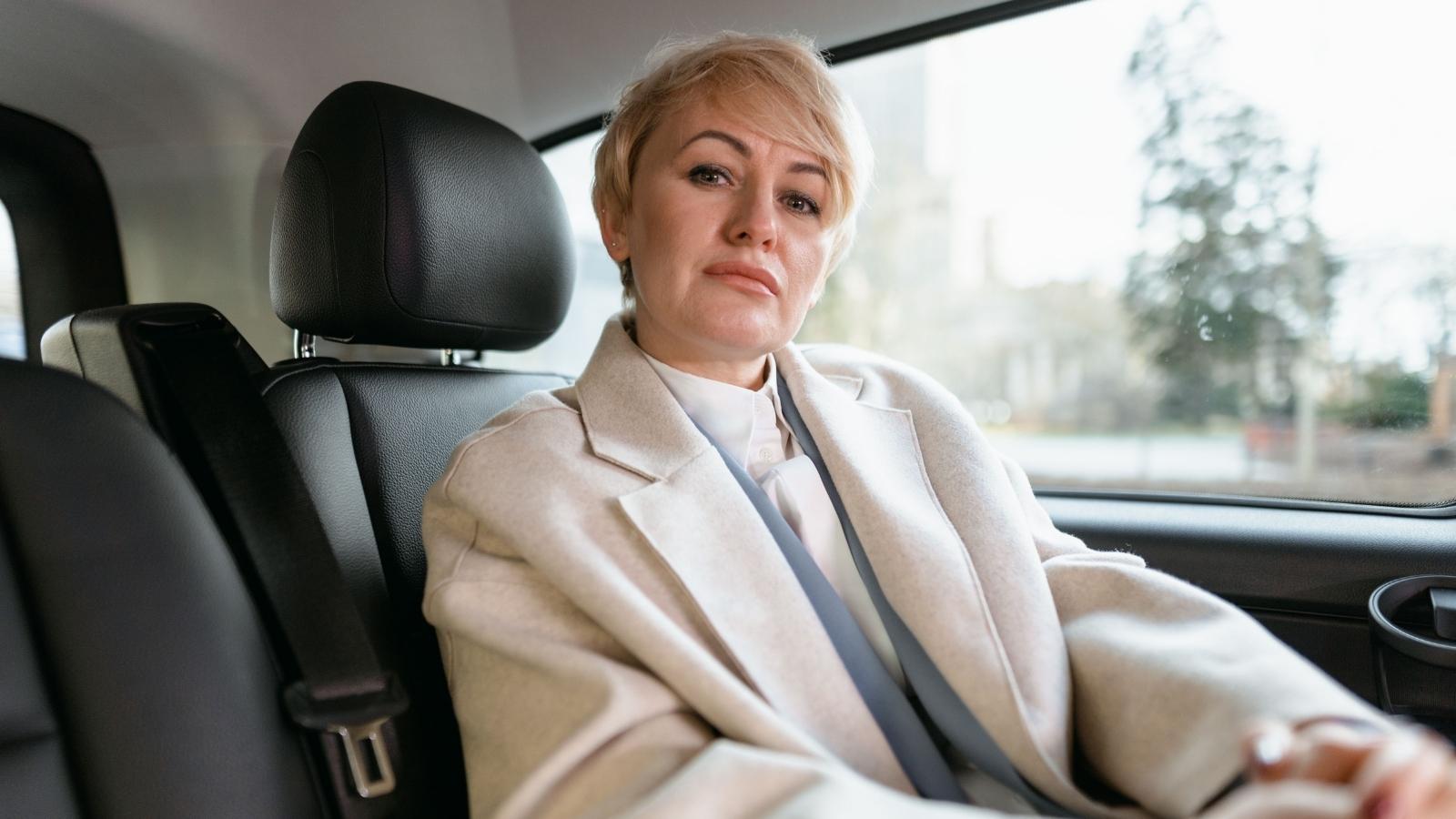 Woman riding in a luxury car with black seats