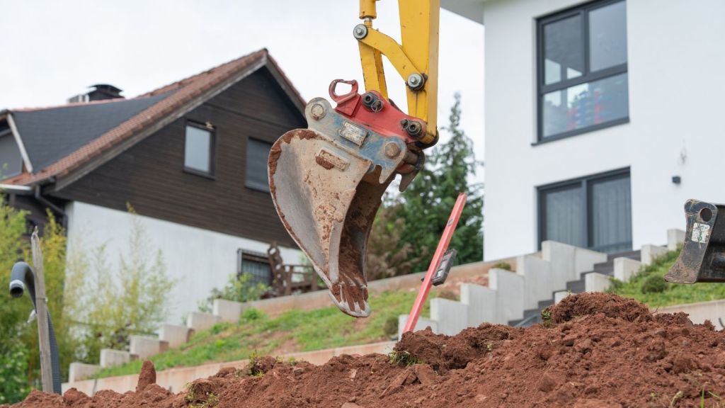 excavator digging up a residential yard