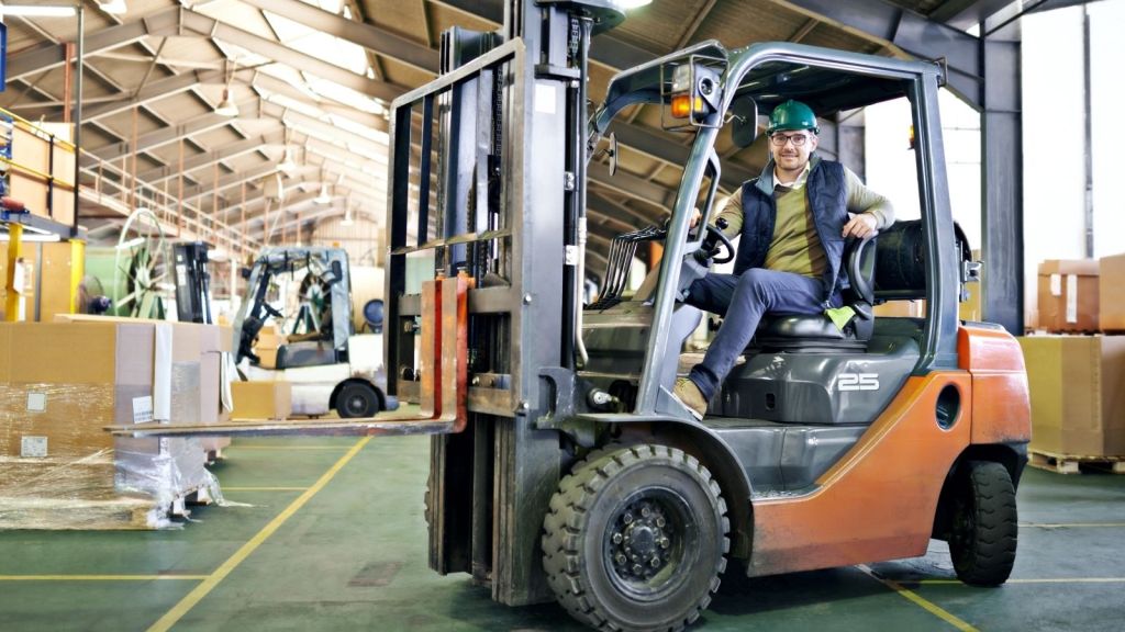 man driving a forklift in a warehouse