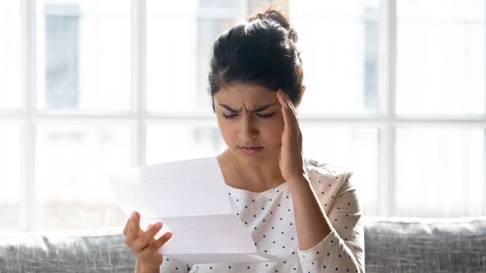 Downstairs Neighbors Complain About Noise, Then HOA Law Firm Sends Young Woman a Warning Letter stressed out young woman reading a letter