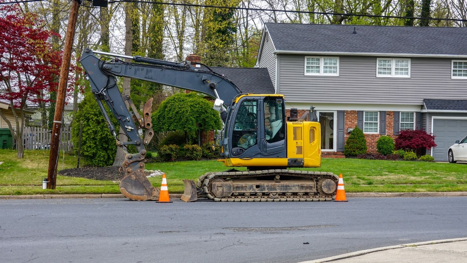 They Parked a Full-Sized Commercial Excavator in Their Front Yard. The Silent Legal Trap Neighbors Are Setting to Force It Off the Block.