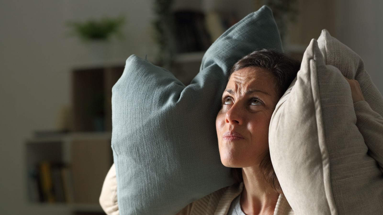 The Unit 4B Crisis: How a Property Managers Dismissive Attitude Backfired Into an Epic Late Night Acoustic Retaliation woman holding pillows over her ears and looking up