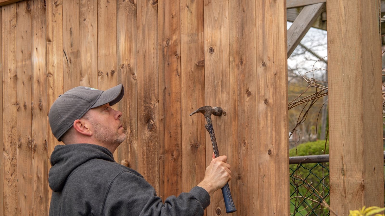 The Property Trap: How a Fed Up Homeowner Used a Hammer and a Survey Map to Deliver the Ultimate Reality Check man building a tall, wooden fence
