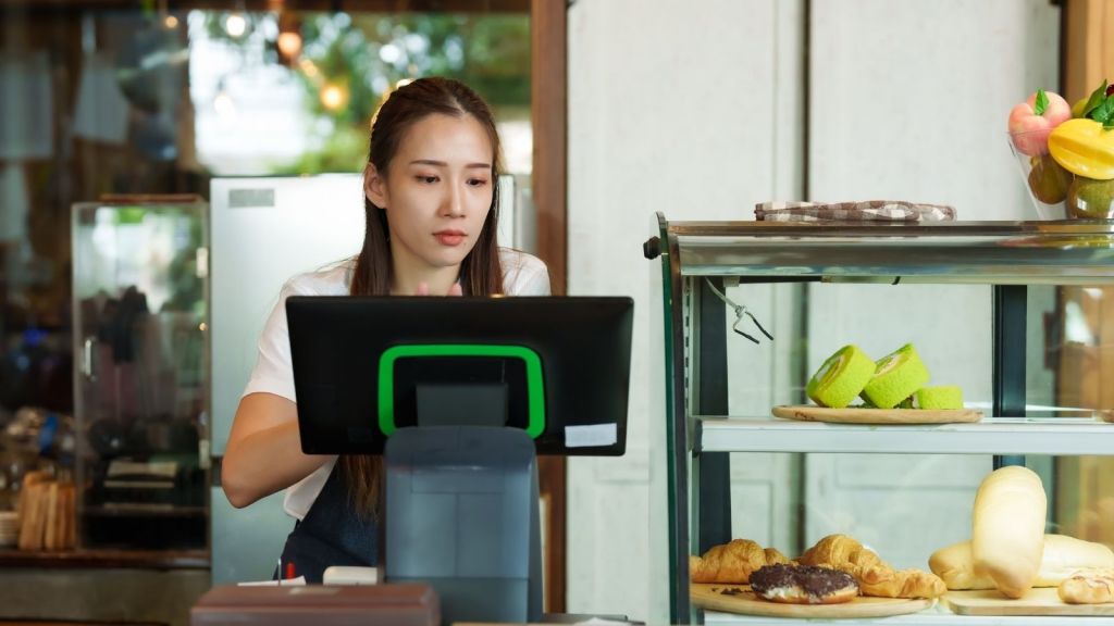 young woman working at restaurant cash register