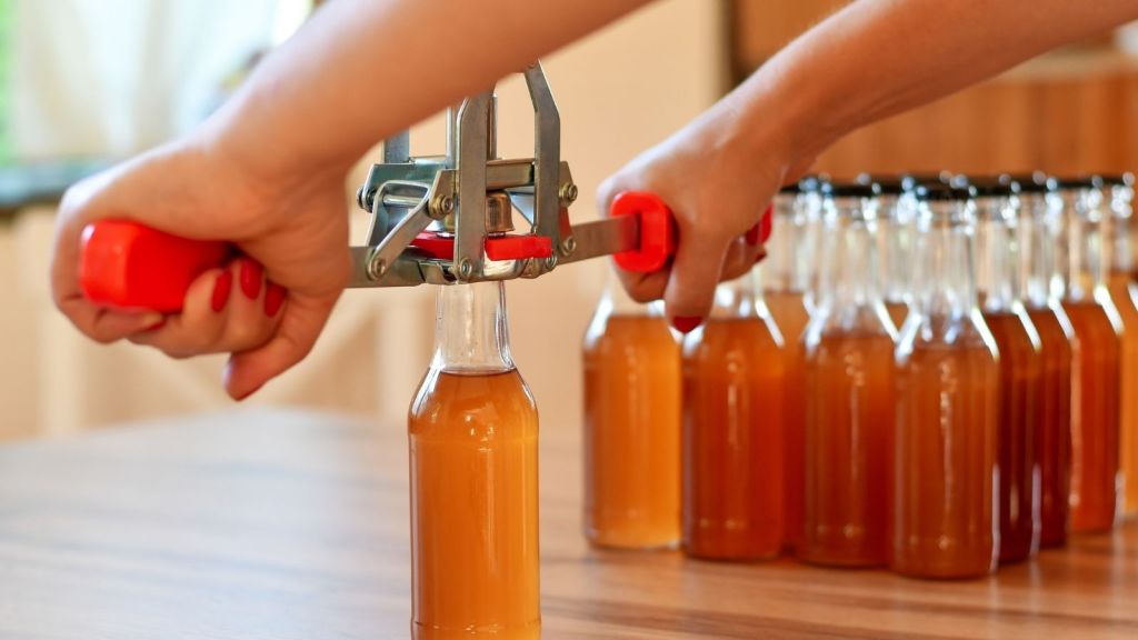putting caps on bottles filled with homemade beer