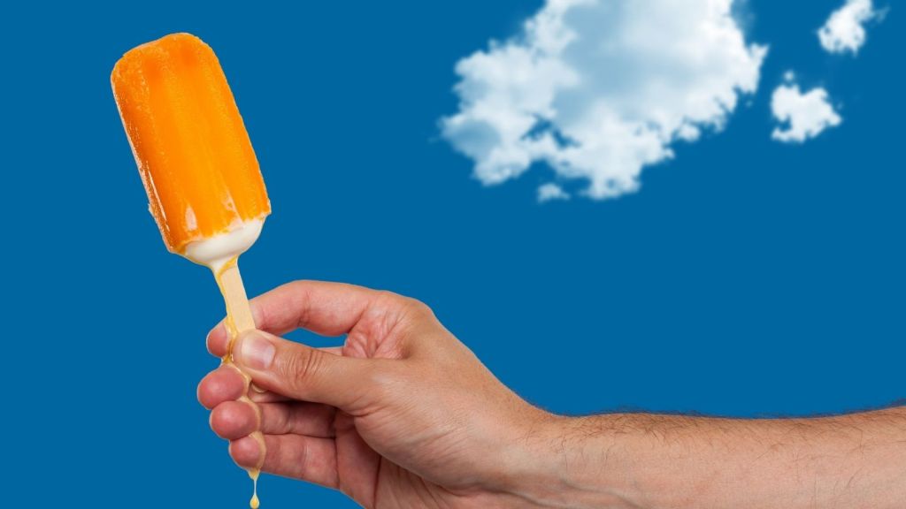 man's hand holding creamsicle ice-cream bar