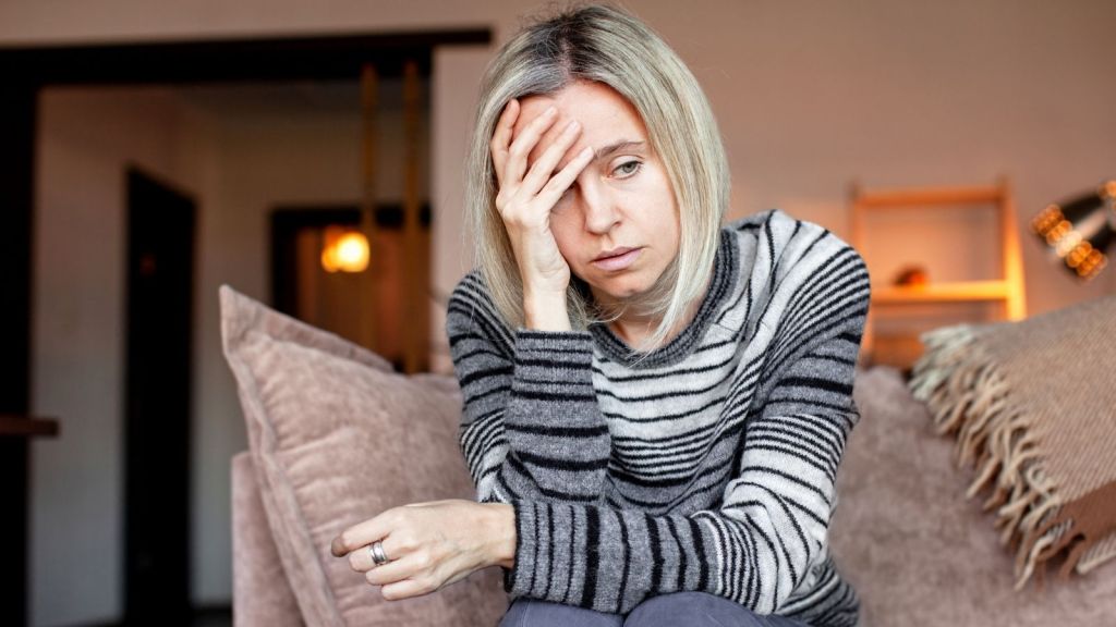 woman sitting on a couch looking worried