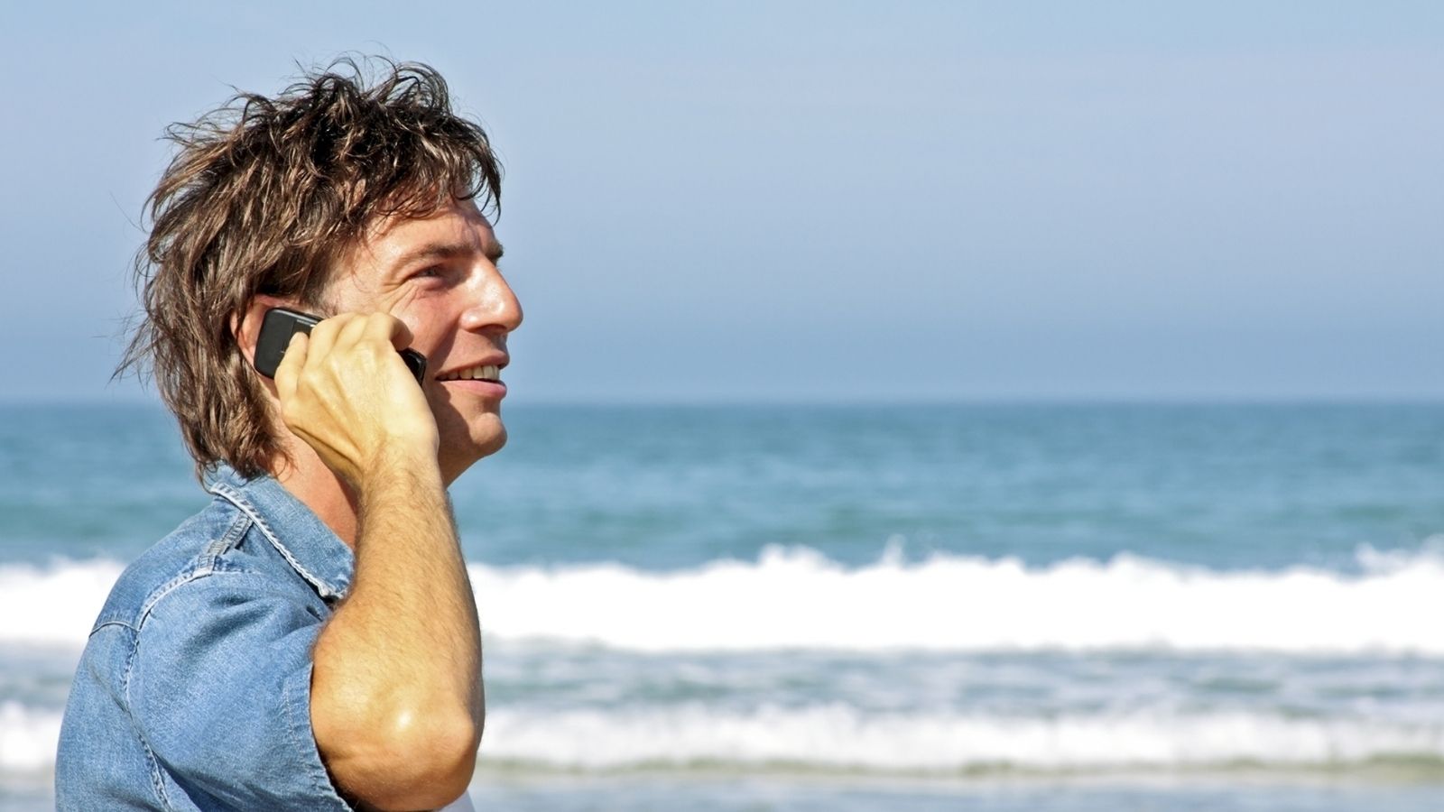 man on the phone at the beach