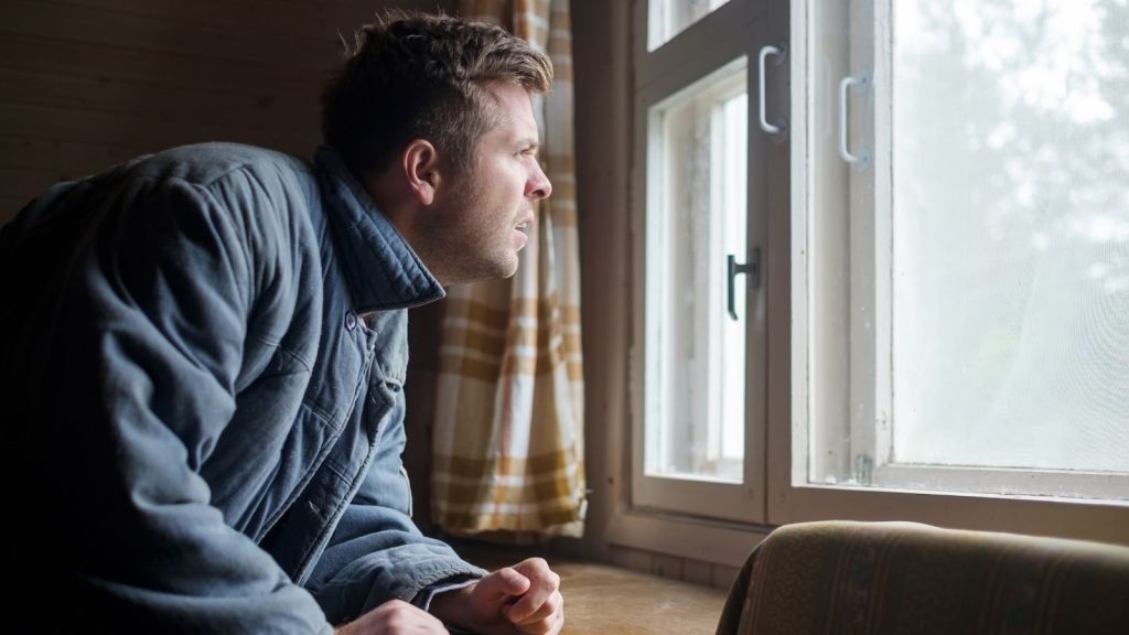 upset man looking out the window