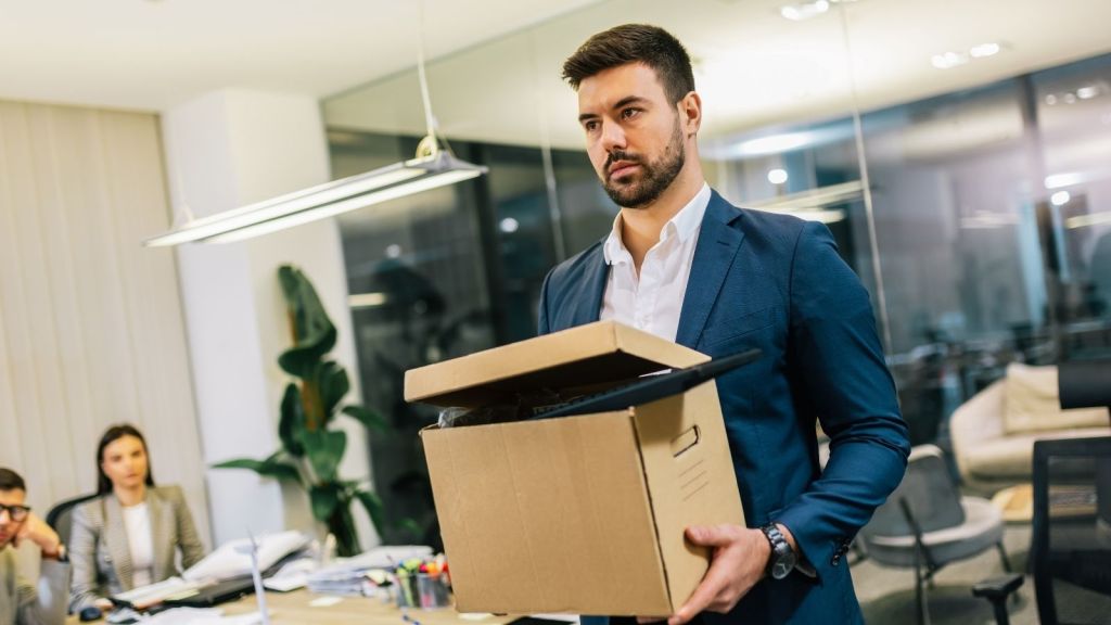 fired businessman carrying a cardboard box