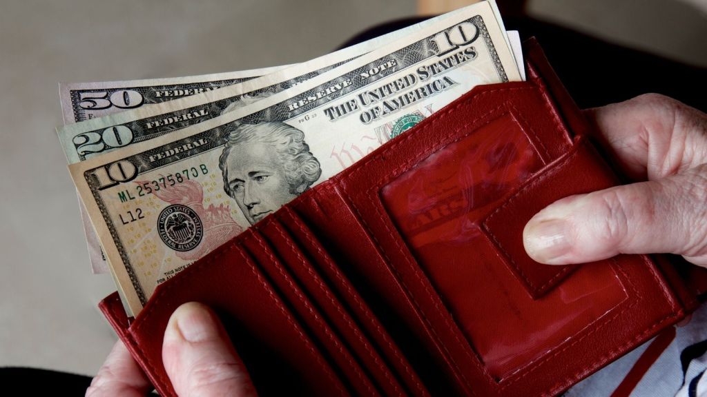 10, 20 and 50 dollar bills in red wallet