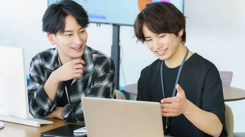 two college students looking at a computer