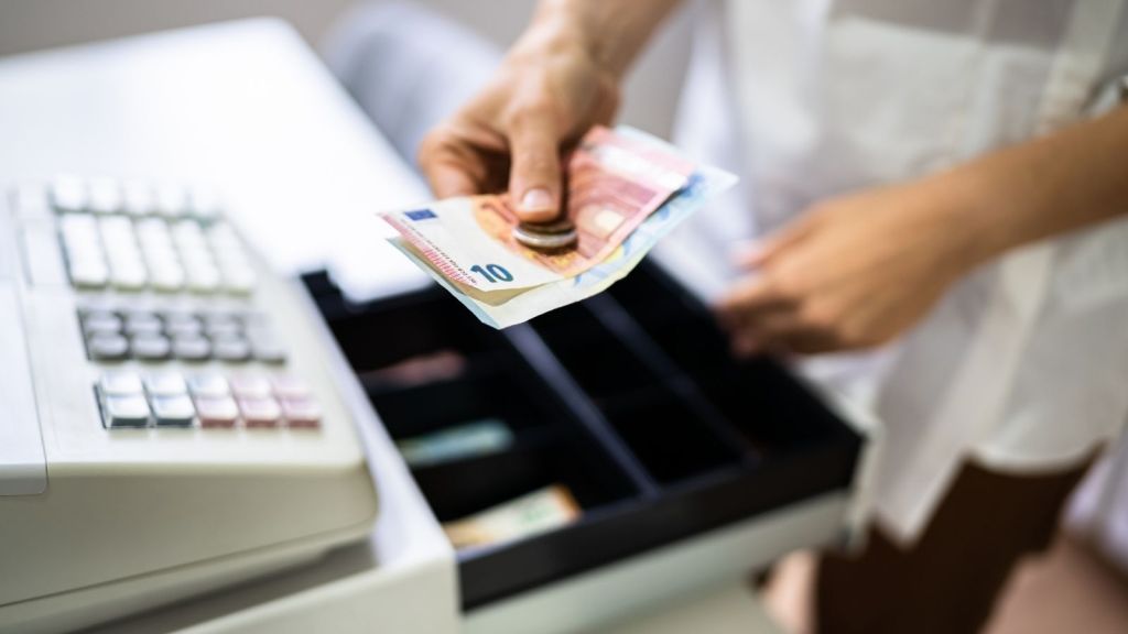 cashier putting cash payment in cash register