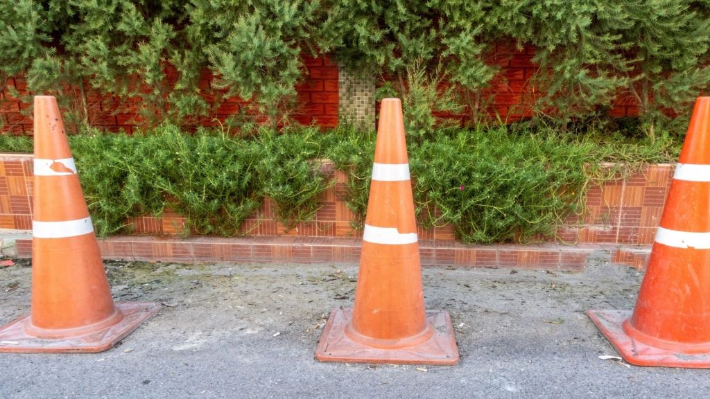 three orange traffic cones on the street