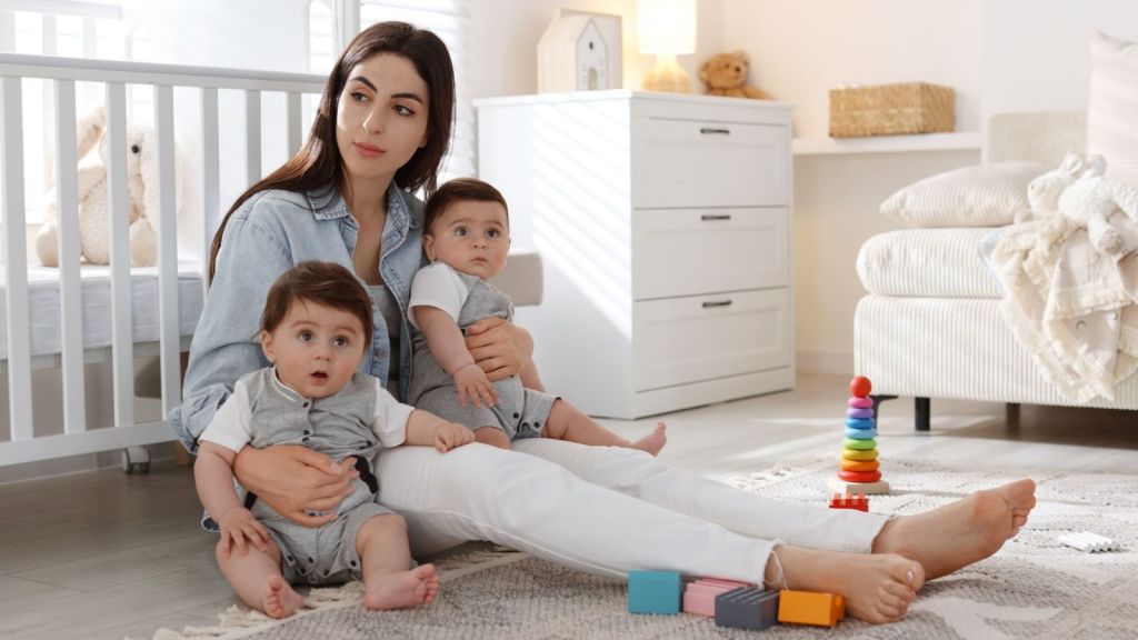 woman sitting on the floor with twin babies