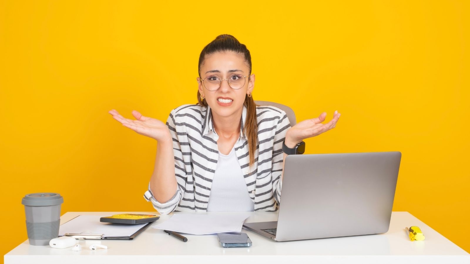She Kept Her Head Down for Months. Then Her Coworkers Bad Attitude and Unfinished Tasks Forced Her to Speak Up. woman sitting at desk shrugging