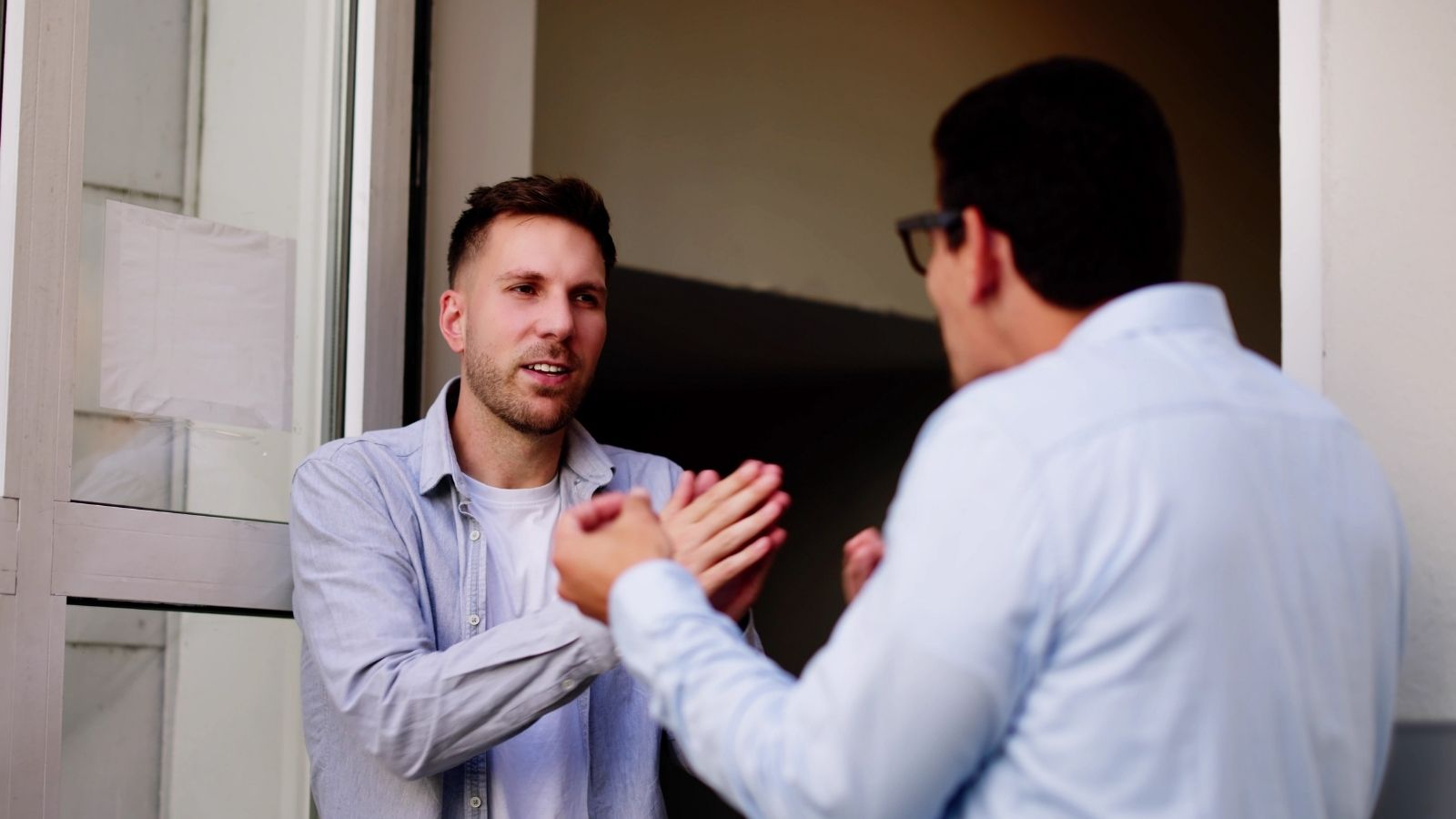 Man Follows The Parking Rules At His New Apartment, But Neighbors Insist Certain Spots Belong To Them two men arguing in a doorway