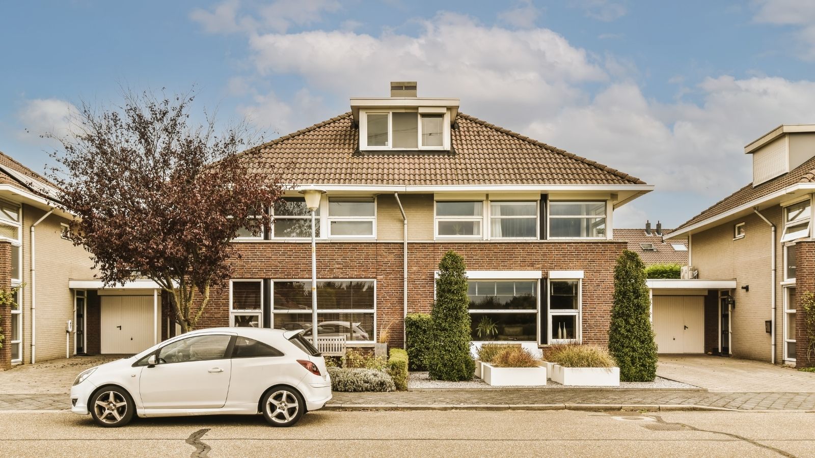 Neighbors Keep Blocking Part Of Their Driveway—And Talking To Them Hasn’t Helped car parked on the street in front of a house