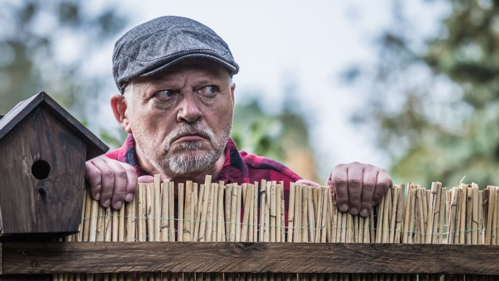 old man spying on neighbors over fence