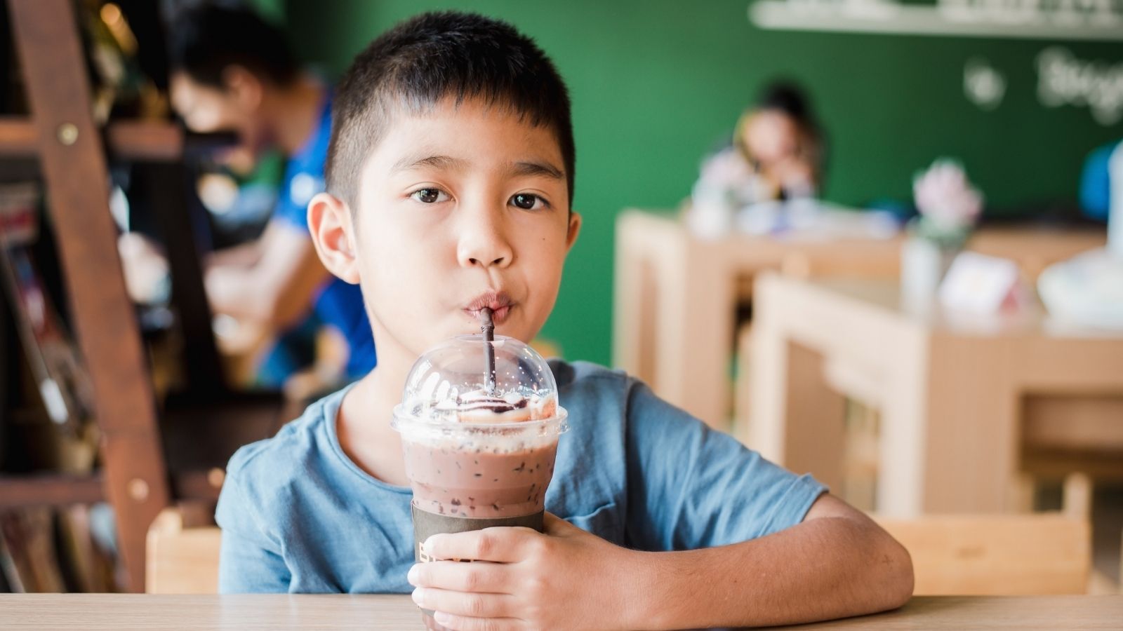 When a Child Orders Like a Regular: The Wholesome Restaurant Interaction That Caught a Server Off Guard boy drinking chocolate milk at a restaurant